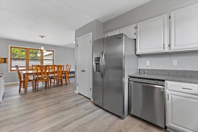 kitchen with pendant lighting, appliances with stainless steel finishes, light stone countertops, light wood-type flooring, and white cabinets