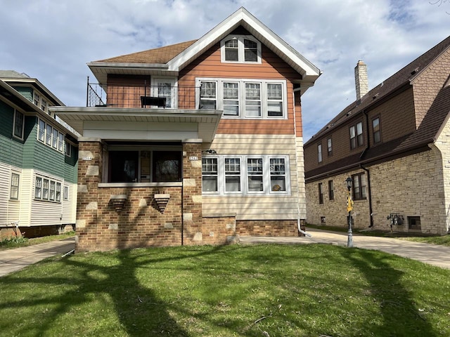 view of front of home featuring a balcony and a front yard