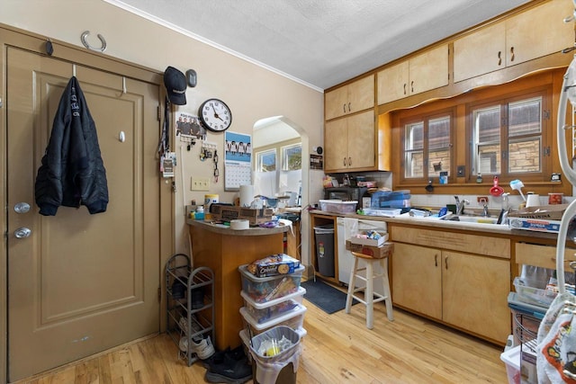 2562 N 68th St Unit 2564, Wauwatosa, WI 53213 - kitchen featuring crown molding, light wood-style floors, arched walkways, a sink, and a textured ceiling