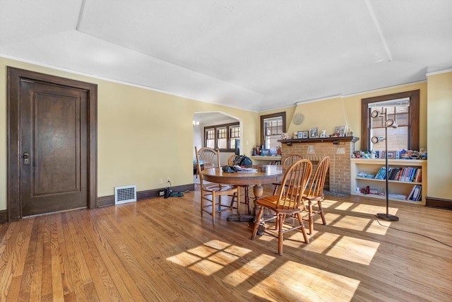 2562 N 68th St Unit 2564, Wauwatosa, WI 53213 - dining area with arched walkways, baseboards, wood finished floors, and a brick fireplace