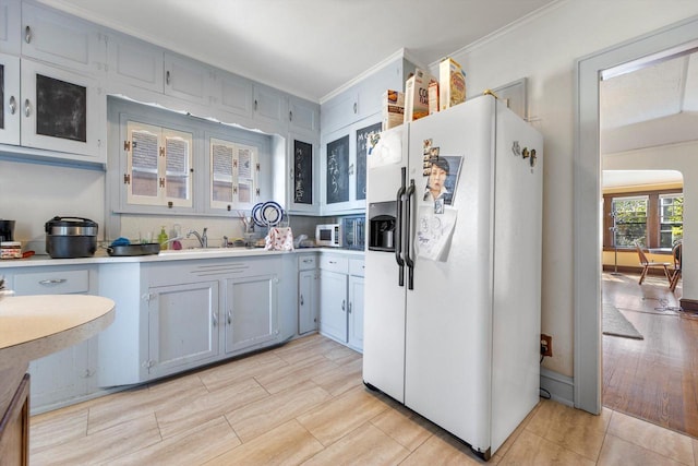 2562 N 68th St Unit 2564, Wauwatosa, WI 53213 - kitchen with white fridge with ice dispenser, light countertops, a sink, ornamental molding, and stainless steel microwave