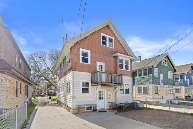 2562 N 68th St Unit 2564, Wauwatosa, WI 53213 - back of house with a balcony, fence, central AC unit, and a residential view
