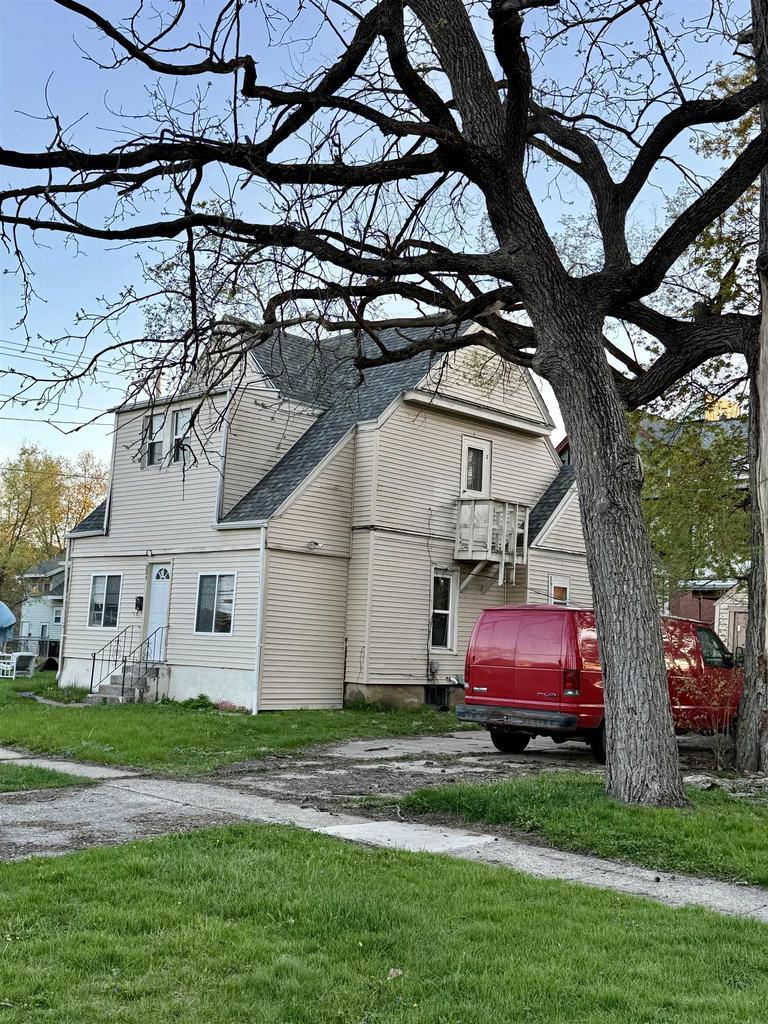 view of front of property with a shingled roof and a front yard