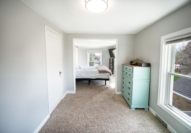 bedroom featuring baseboards and light carpet