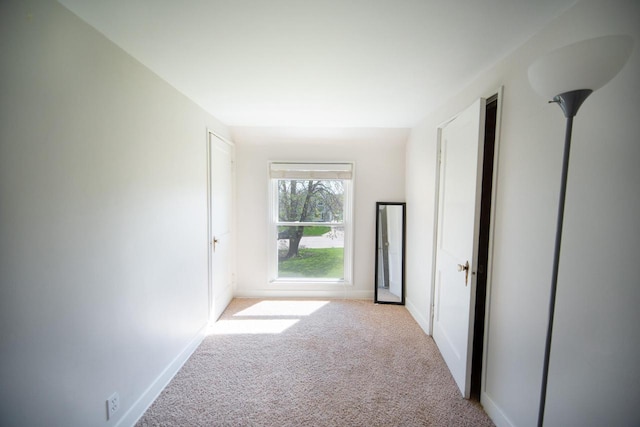 hall with baseboards and carpet flooring