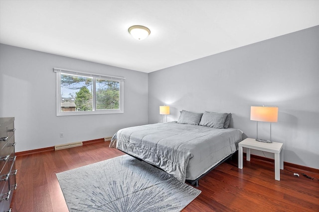 bedroom with baseboards, visible vents, and wood finished floors