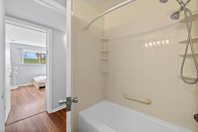 bathroom with baseboards, bathing tub / shower combination, and wood finished floors