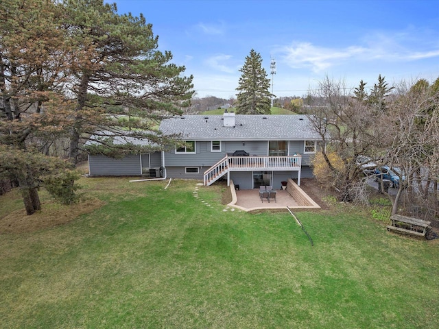 rear view of property with roof with shingles, a lawn, a wooden deck, a patio area, and cooling unit