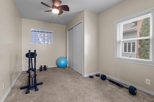 workout room featuring baseboards, ceiling fan, carpet flooring, and a wealth of natural light