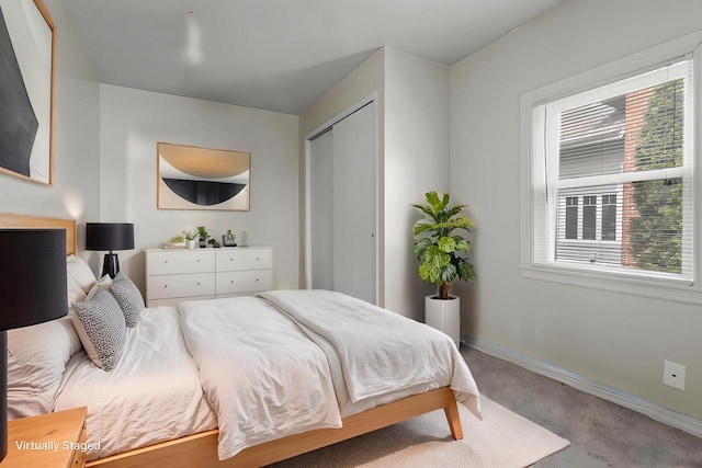 bedroom with carpet floors, baseboards, a closet, and multiple windows