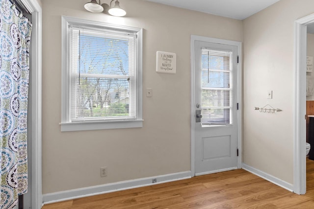 entryway with baseboards, plenty of natural light, and light wood-type flooring