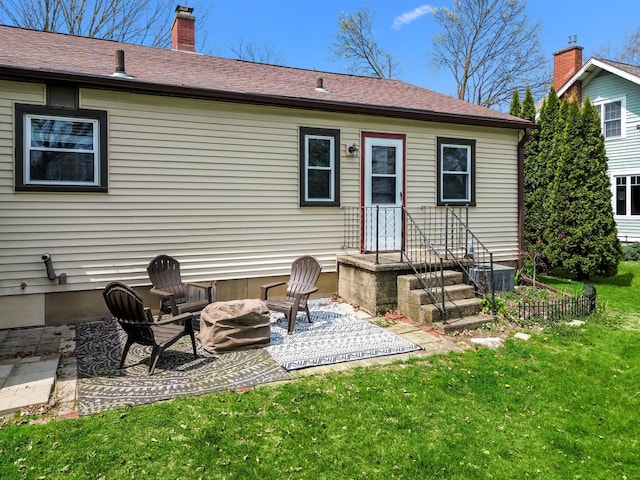 back of house featuring a lawn, a chimney, and a patio area