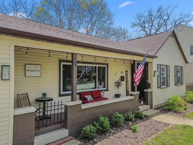 exterior space with covered porch and a shingled roof