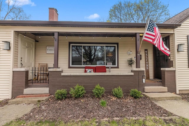 view of front of home featuring covered porch and a chimney