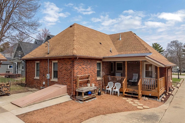 233 N 1st St, Princeton, WI 54968 - back of property with roof with shingles, brick siding, and covered porch