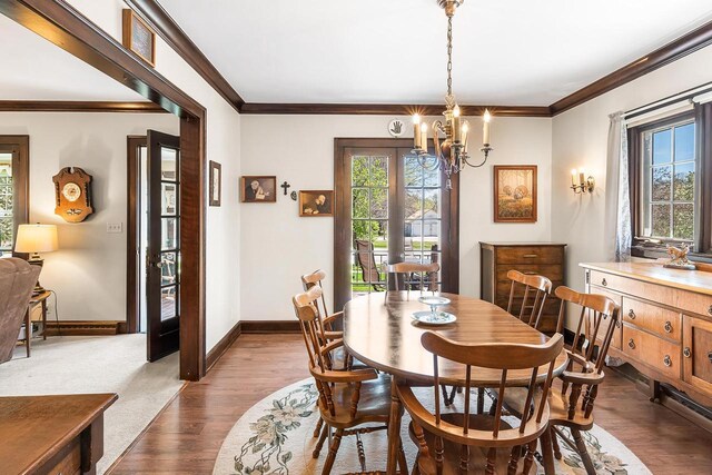 233 N 1st St, Princeton, WI 54968 - dining space with ornamental molding, a chandelier, baseboards, and dark wood-style flooring