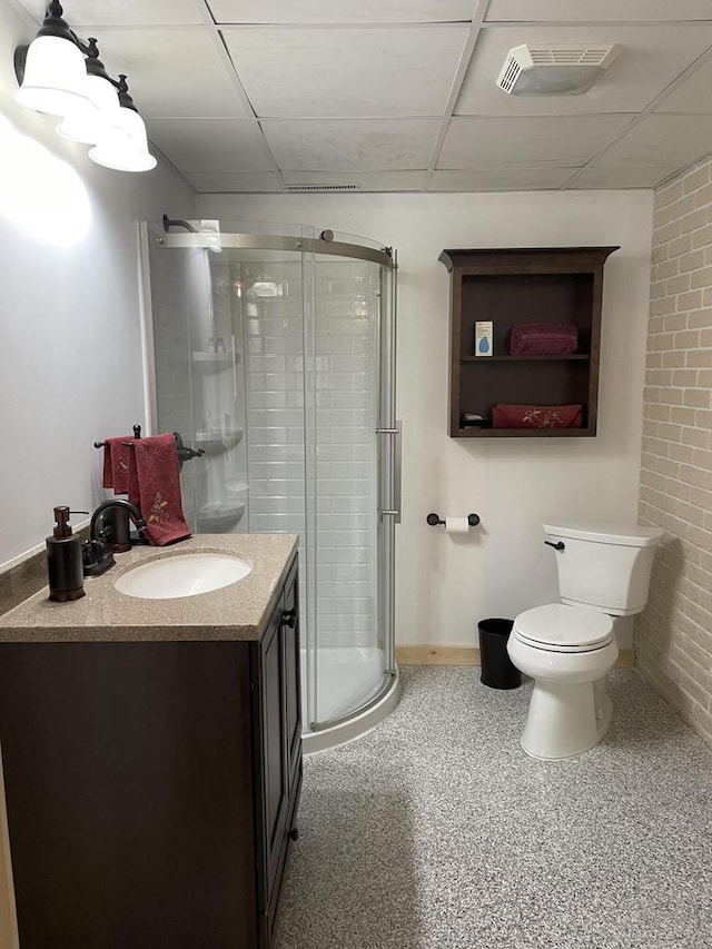 full bath with vanity, toilet, a paneled ceiling, a shower stall, and visible vents