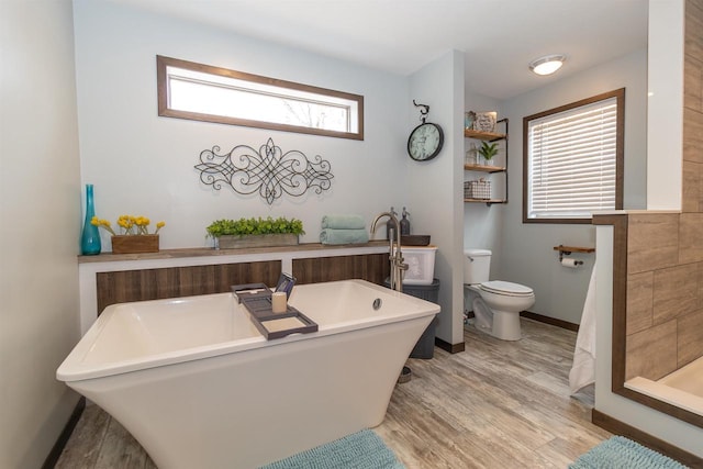 436 Duffers Trl, Nekoosa, WI 54469 - bathroom with baseboards, toilet, a freestanding tub, and wood finished floors