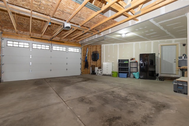 436 Duffers Trl, Nekoosa, WI 54469 - garage featuring black fridge and a garage door opener