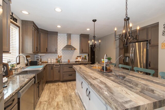 436 Duffers Trl, Nekoosa, WI 54469 - kitchen featuring appliances with stainless steel finishes, a sink, light wood finished floors, a chandelier, and wall chimney exhaust hood