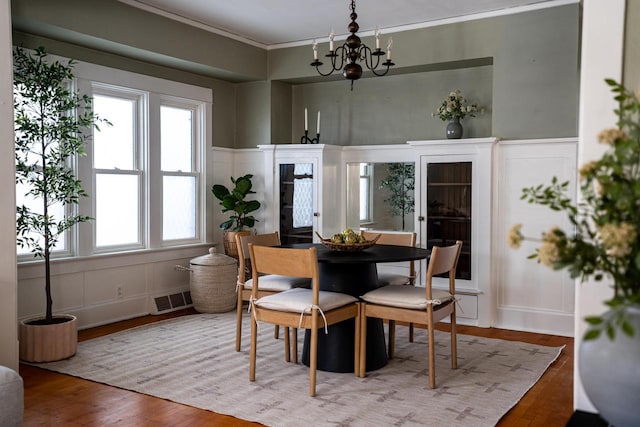 dining area with visible vents, a wealth of natural light, and a decorative wall