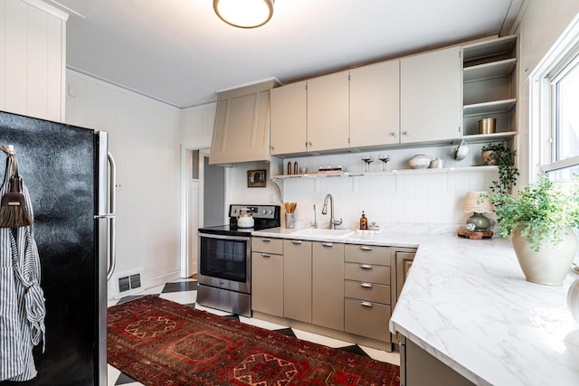 kitchen featuring visible vents, open shelves, light stone countertops, a sink, and stainless steel appliances