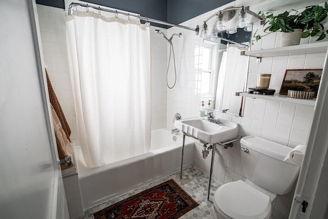 bathroom with tile walls, toilet, and shower / bath combination with curtain