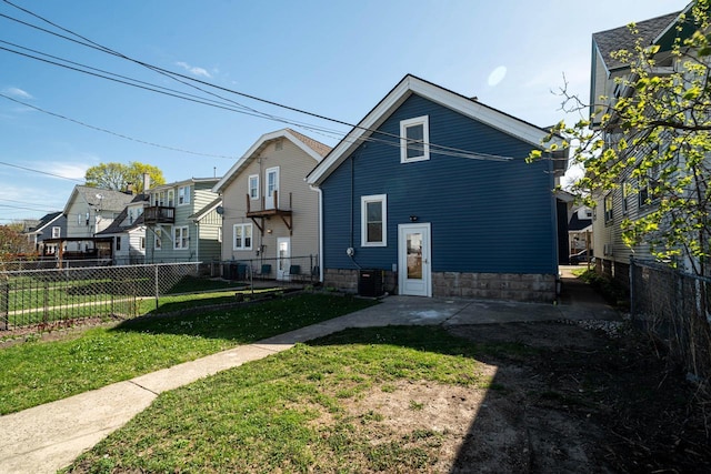back of property featuring a lawn, fence, and central AC unit