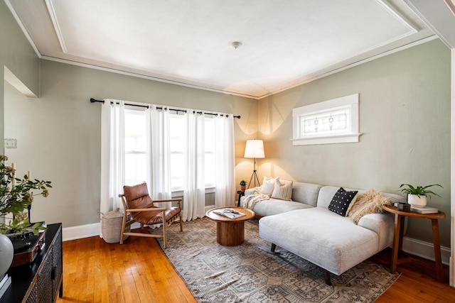living area with crown molding, light wood-style flooring, and baseboards