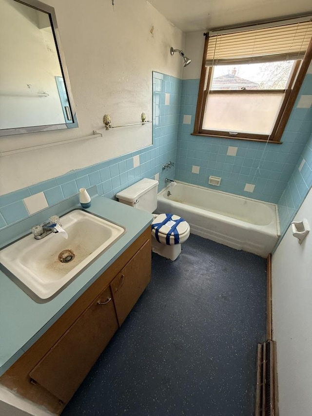 bathroom featuring toilet, tile walls, shower / tub combination, and vanity