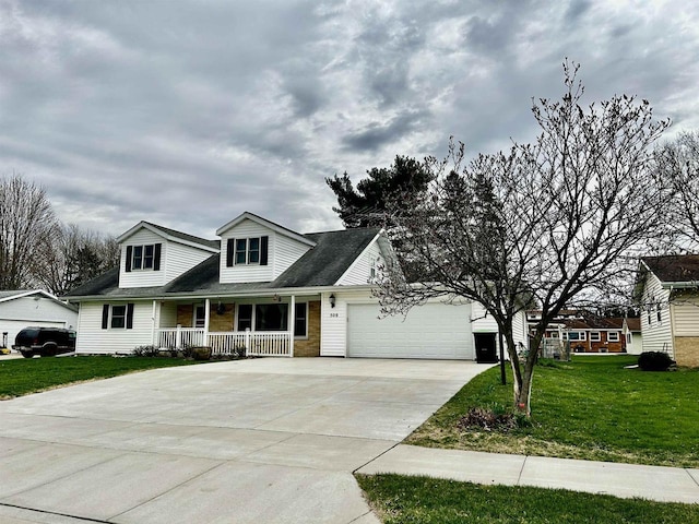 cape cod-style house featuring a garage, covered porch, concrete driveway, and a front lawn