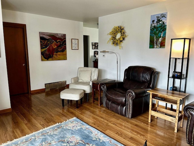 living room featuring baseboards, wood finished floors, and visible vents