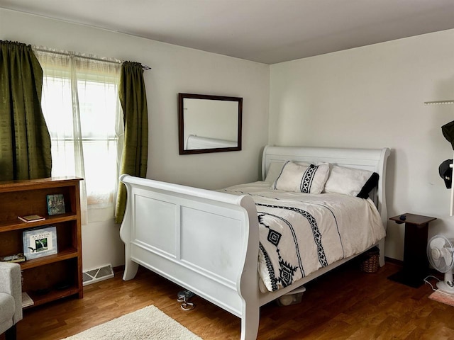 bedroom featuring visible vents and wood finished floors