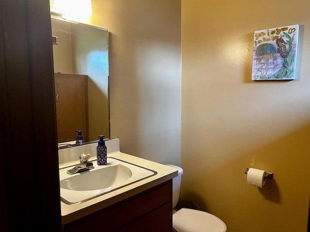 half bathroom with vanity and toilet