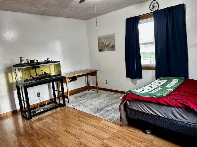 bedroom with baseboards and wood finished floors