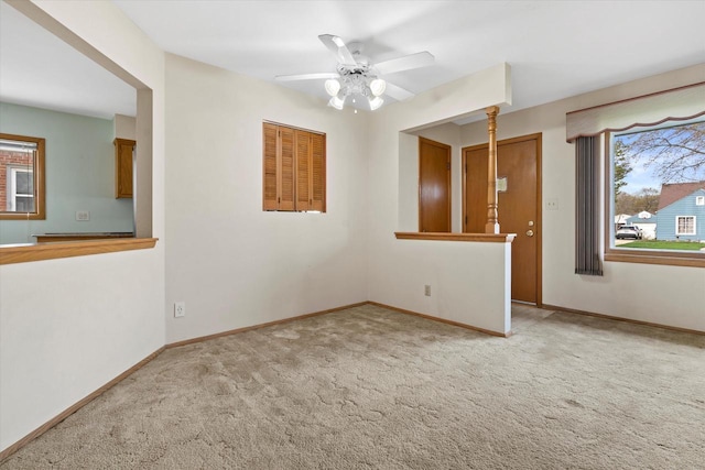 spare room featuring a ceiling fan, baseboards, and carpet