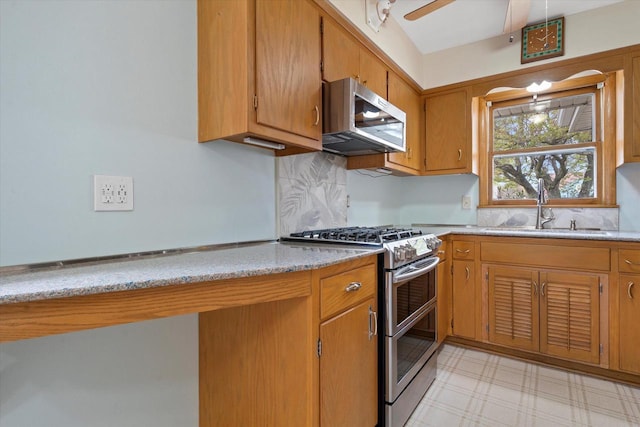 kitchen featuring a sink, backsplash, stainless steel appliances, and brown cabinetry
