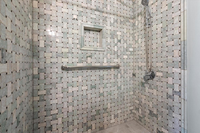 full bathroom featuring tile patterned flooring and a tile shower