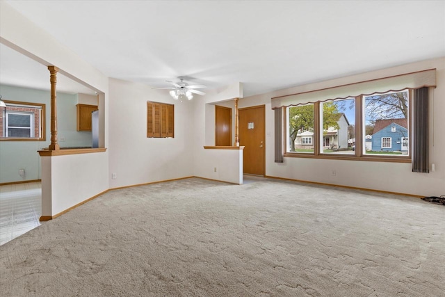 unfurnished living room featuring carpet floors, baseboards, and ceiling fan