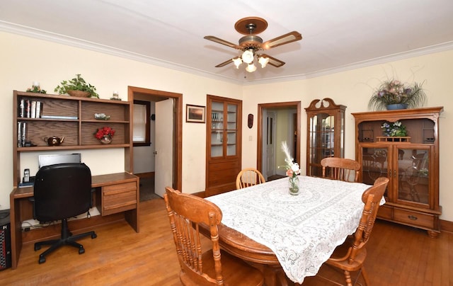 dining area with ceiling fan, ornamental molding, and wood finished floors