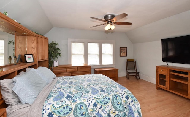 bedroom featuring light wood-type flooring, a ceiling fan, baseboards, and lofted ceiling