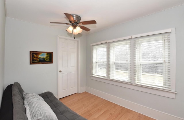 sitting room with baseboards, ceiling fan, and light wood-type flooring