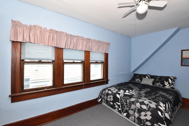 carpeted bedroom featuring baseboards and a ceiling fan