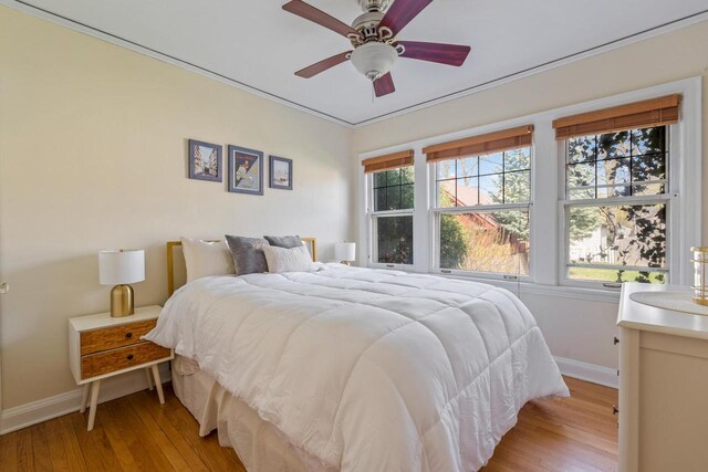 bedroom featuring baseboards, multiple windows, and light wood-style flooring