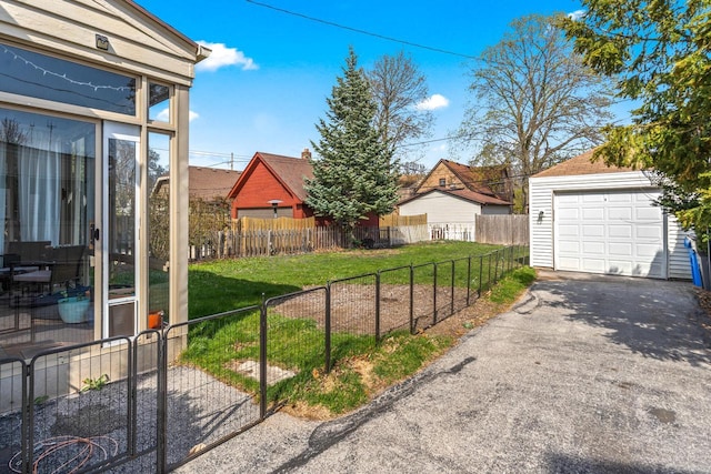 view of yard with an outdoor structure, a garage, fence, and driveway