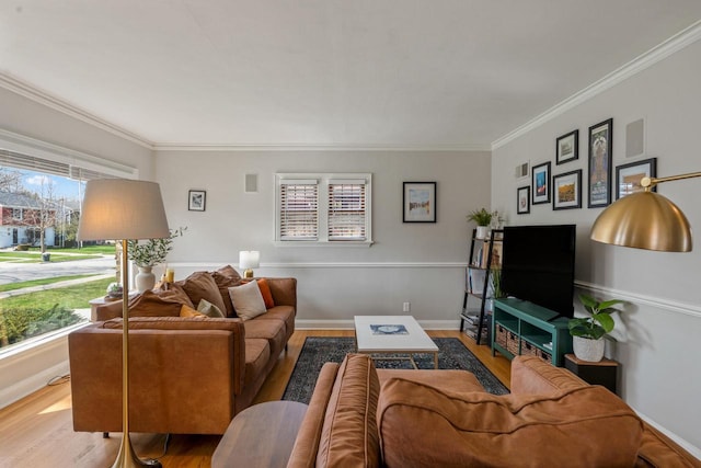 living area with crown molding, baseboards, and wood finished floors