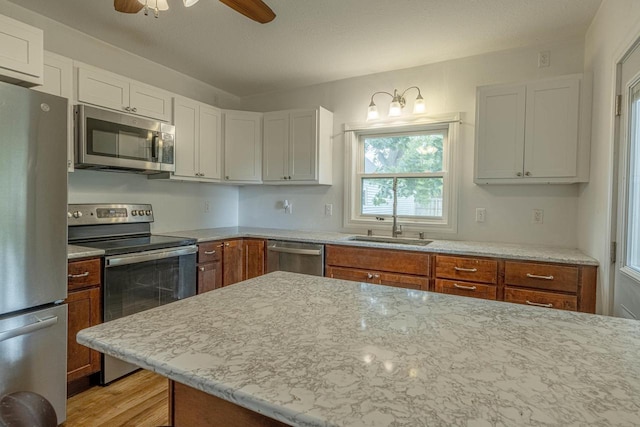 2334 16th Ave, Monroe, WI 53566 - kitchen with stainless steel appliances, a sink, ceiling fan, white cabinetry, and brown cabinets