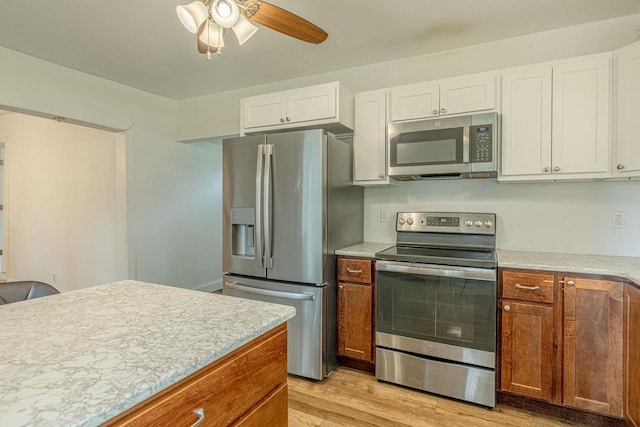 2334 16th Ave, Monroe, WI 53566 - kitchen with stainless steel appliances, a ceiling fan, light countertops, light wood finished floors, and white cabinetry