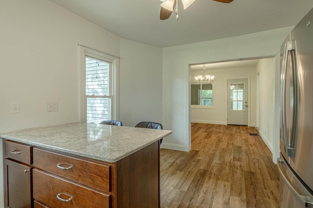 2334 16th Ave, Monroe, WI 53566 - kitchen featuring freestanding refrigerator, a ceiling fan, light wood finished floors, a chandelier, and baseboards
