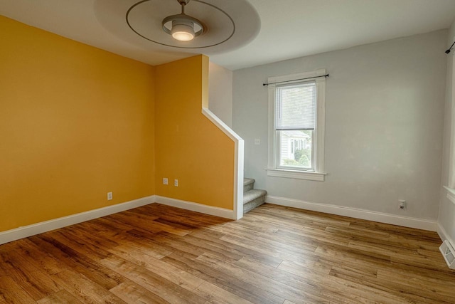 2334 16th Ave, Monroe, WI 53566 - spare room with stairs, wood finished floors, and baseboards